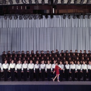 Mireille Mathieu At The Palais Des Sports With The Choirs Of The Red Army. En France, à Paris, en novembre 1967, lors d'un concert au Palais des Sports, Mireille MATHIEU, chanteuse, portant un robe rouge, sur scène avec les coeurs de l'armée rouge. (Photo by Jean Tesseyre/Paris Match via Getty Images)