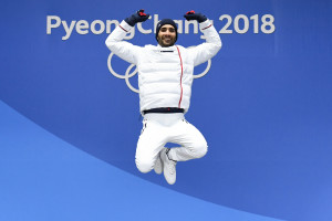 France's gold medallist Martin Fourcade jumps on the podium during the medal ceremony for the biathlon men's 15km Mass Start at the Pyeongchang Medals Plaza during the Pyeongchang 2018 Winter Olympic Games in Pyeongchang on February 19, 2018. / AFP PHOTO / Kirill KUDRYAVTSEV